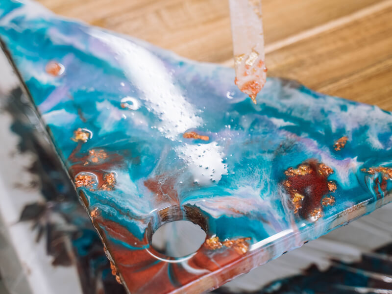 Close up of colourful mixed paints poured onto a wooden board
